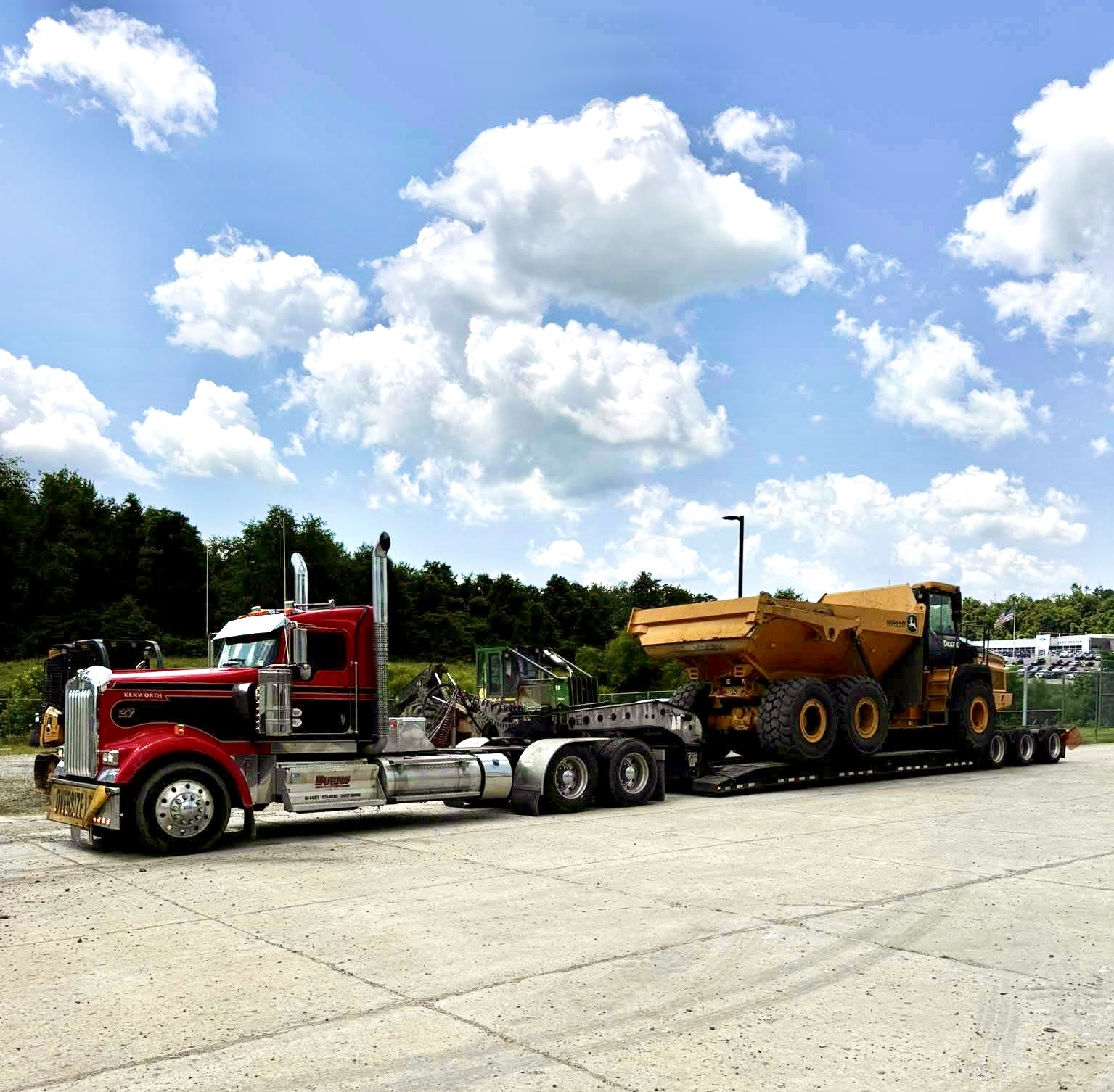 Here is the alt text for the image: "An extreme close-up image of a tire track in the dirt, with grass and a fence in the ...